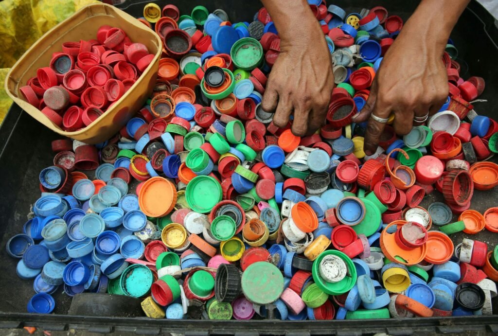 pexels photo 761297 761297 A vibrant assortment of plastic bottle caps being sorted by hand for recycling in Manila.
